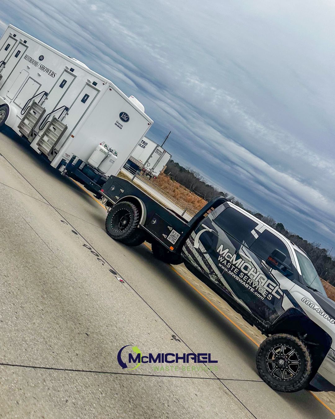 McMichael Waste Services truck towing restroom shower trailer Alabama highway delivery